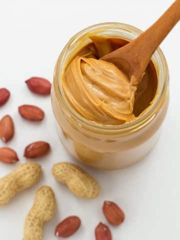 a jar of peanut butter with a spoon in it.