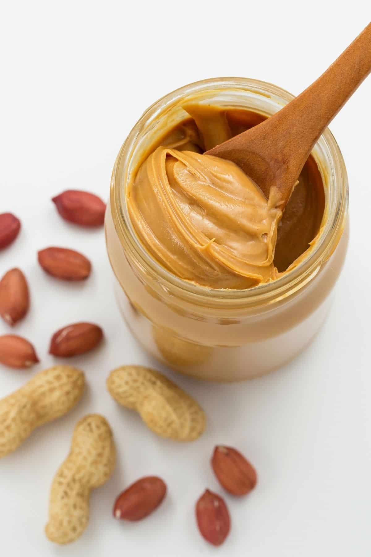 A jar of peanut butter with a spoon in it.