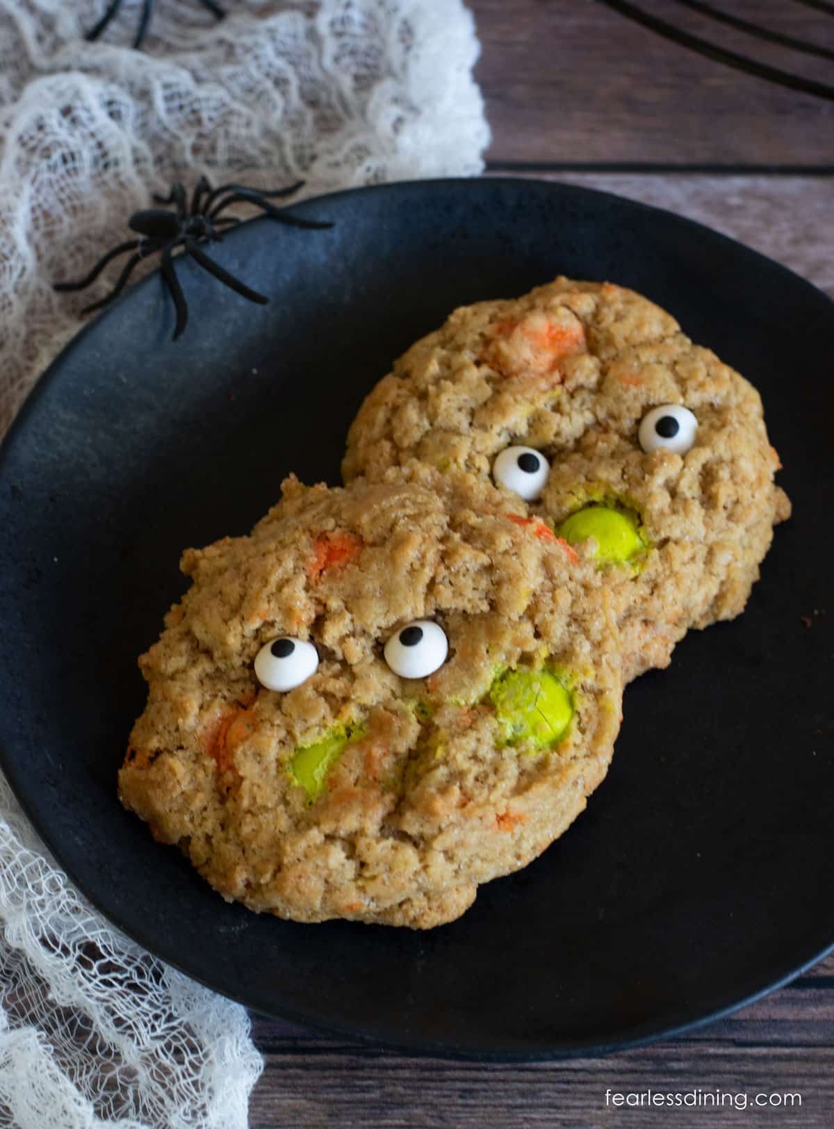 Two baked Halloween cookies on a black plate.
