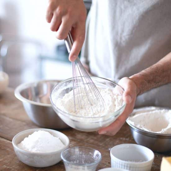 whisking dry ingredients in a glass bowl.