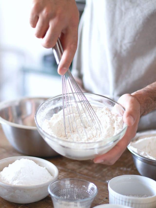 whisking dry ingredients in a glass bowl.