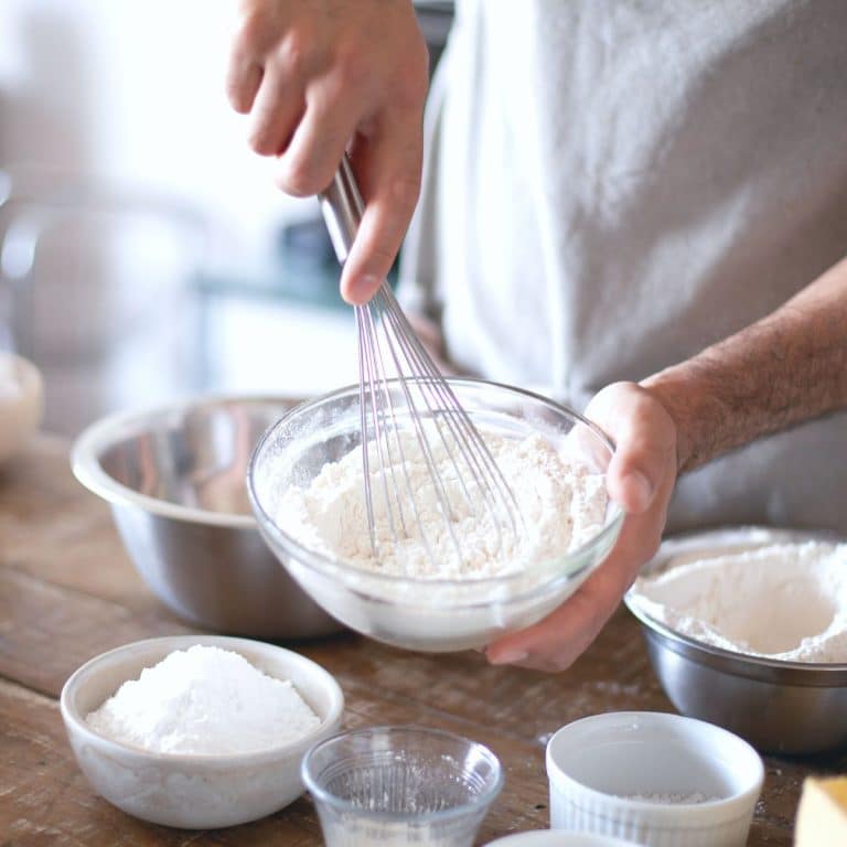 Whisking dry ingredients in a glass bowl.