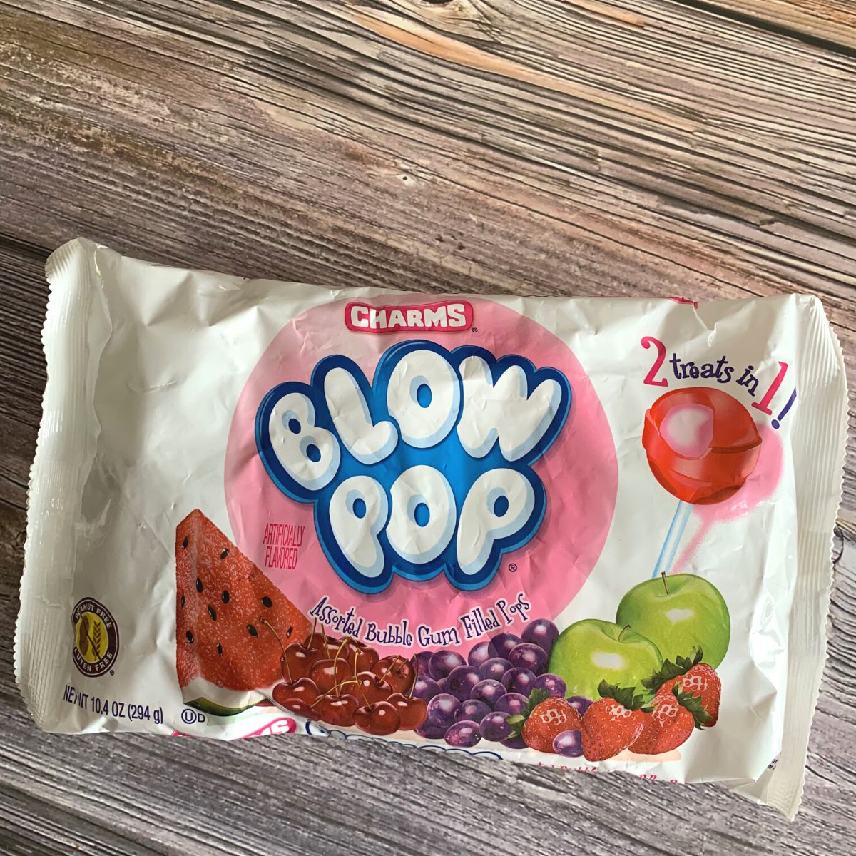 A bag of blow pops on a wooden table.