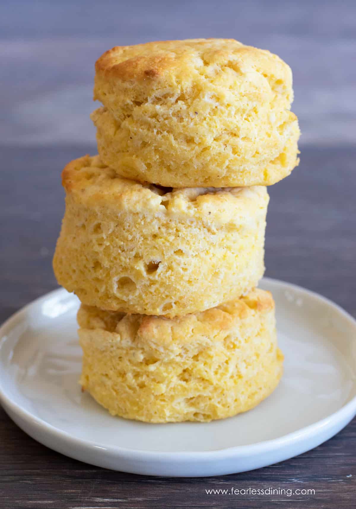 Three gluten free cornmeal biscuits stacked on top of each other.