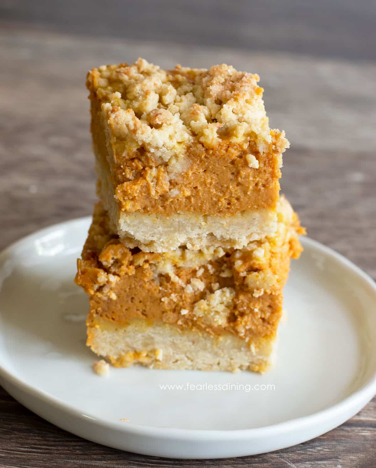 Two gluten free pumpkin pie bars stacked on top of each other.
