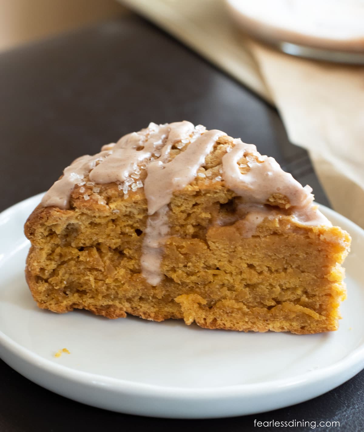 A gluten free pumpkin scone on a small white plate.