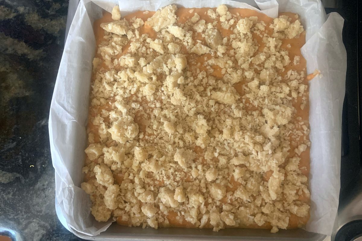 An 8x8 baking dish with the uncooked pumpkin pie bars.