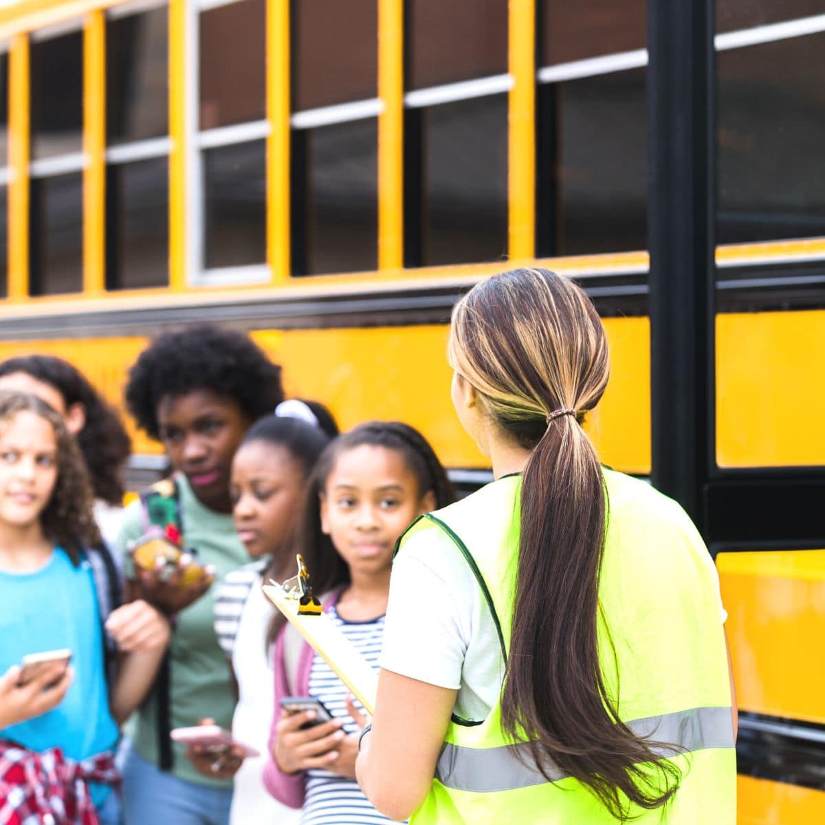 Kids waiting to get onto a school bus.