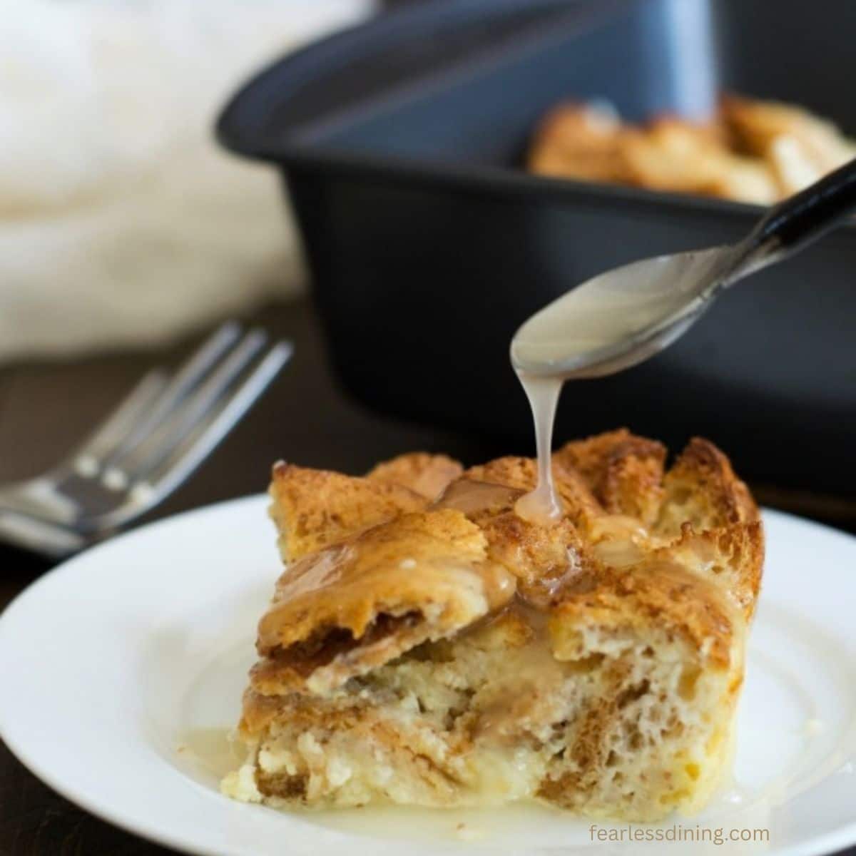Drizzling vanilla sauce over the bread pudding.