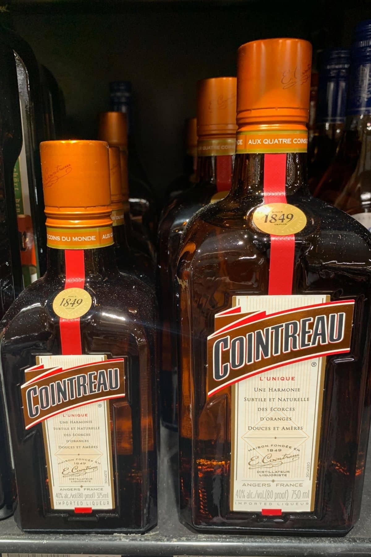 Several bottles of cointreau on a shelf.