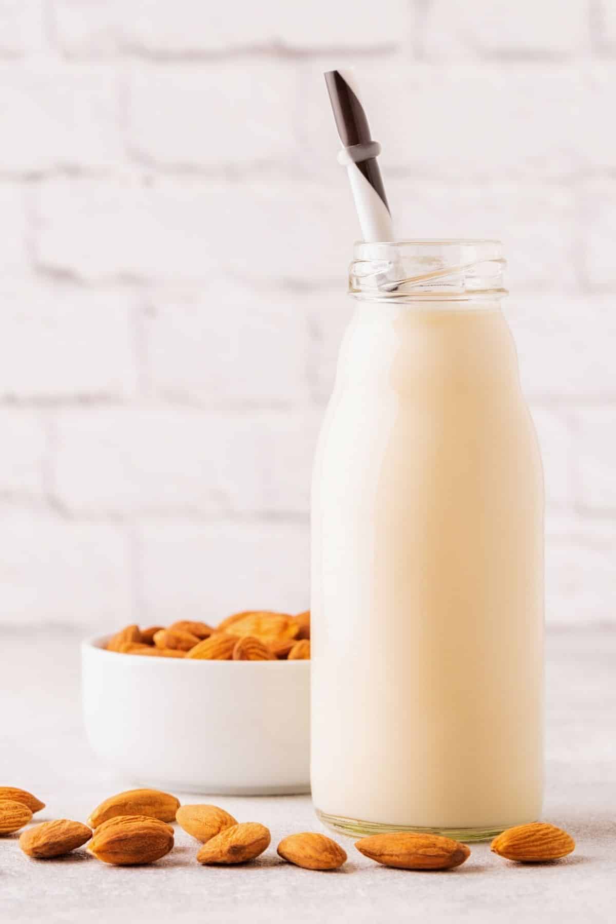 A tall glass jar of almond milk.