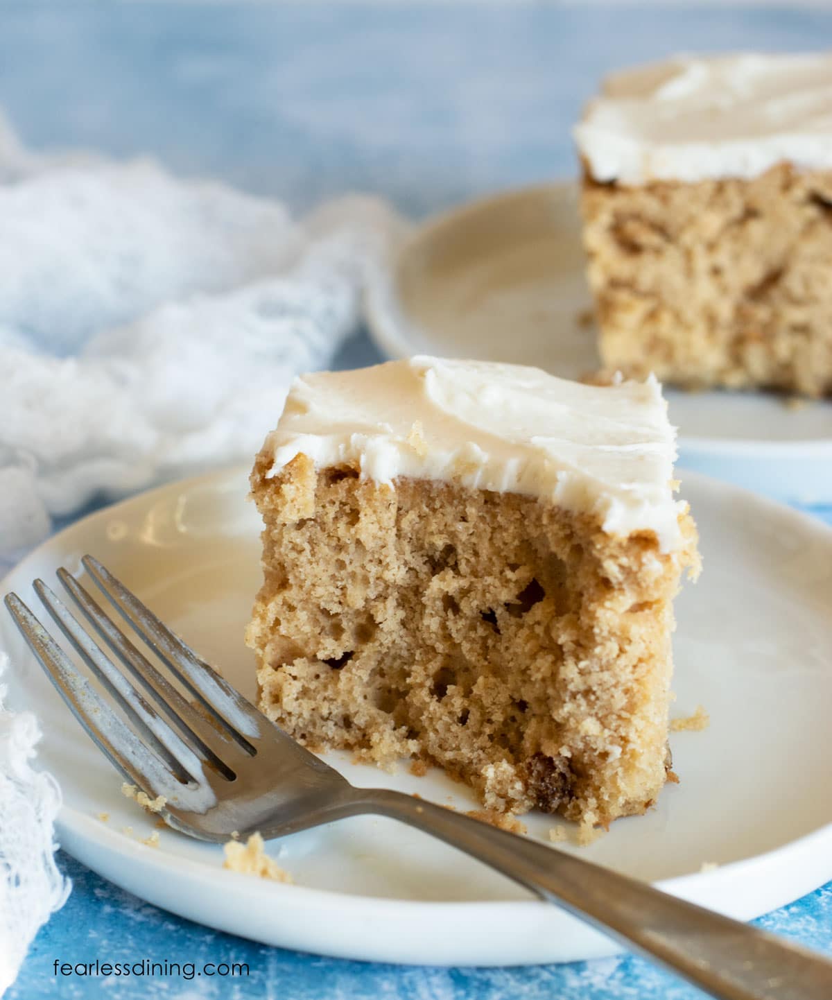 A piece of frosted cake with a bite cut out.