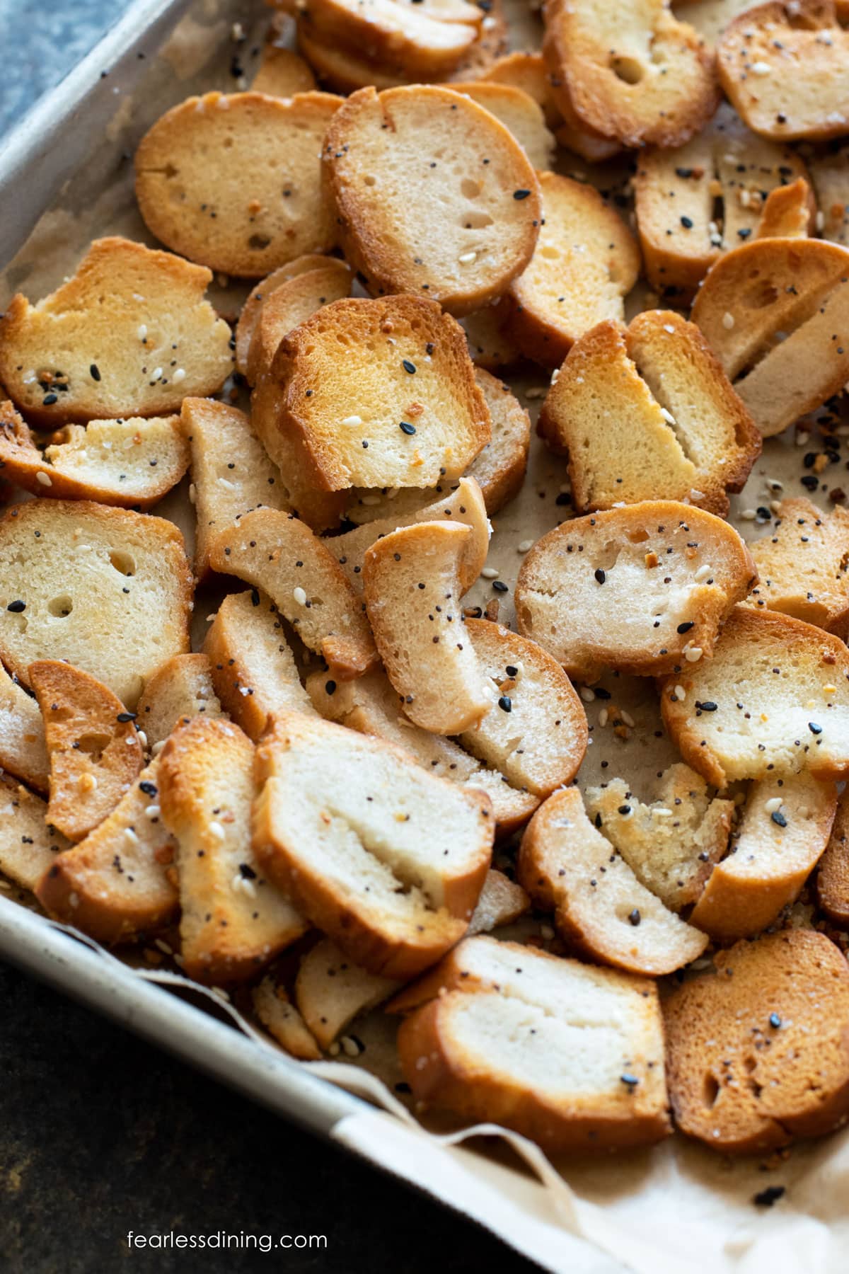 The baked gluten free bagel chips on a baking sheet.