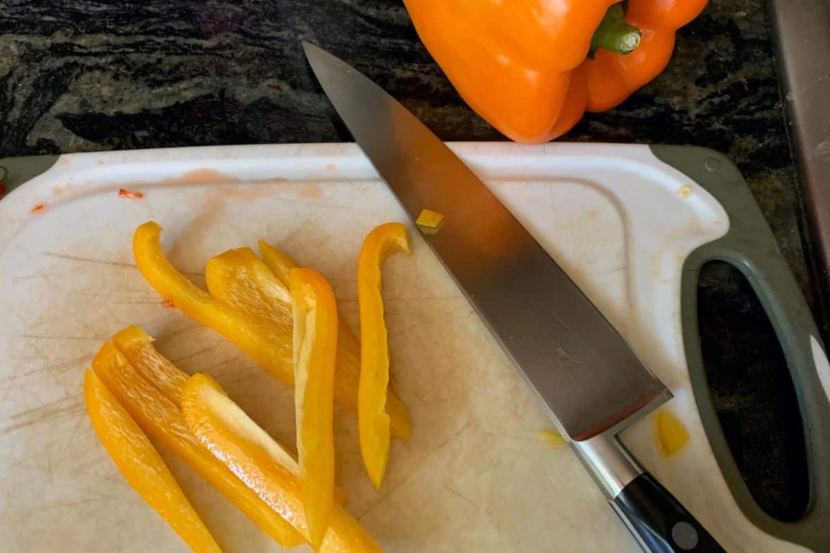 sliced yellow peppers on a cutting board.