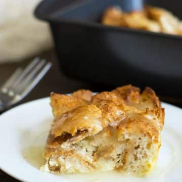 A slice of gluten free bread pudding on a white plate.