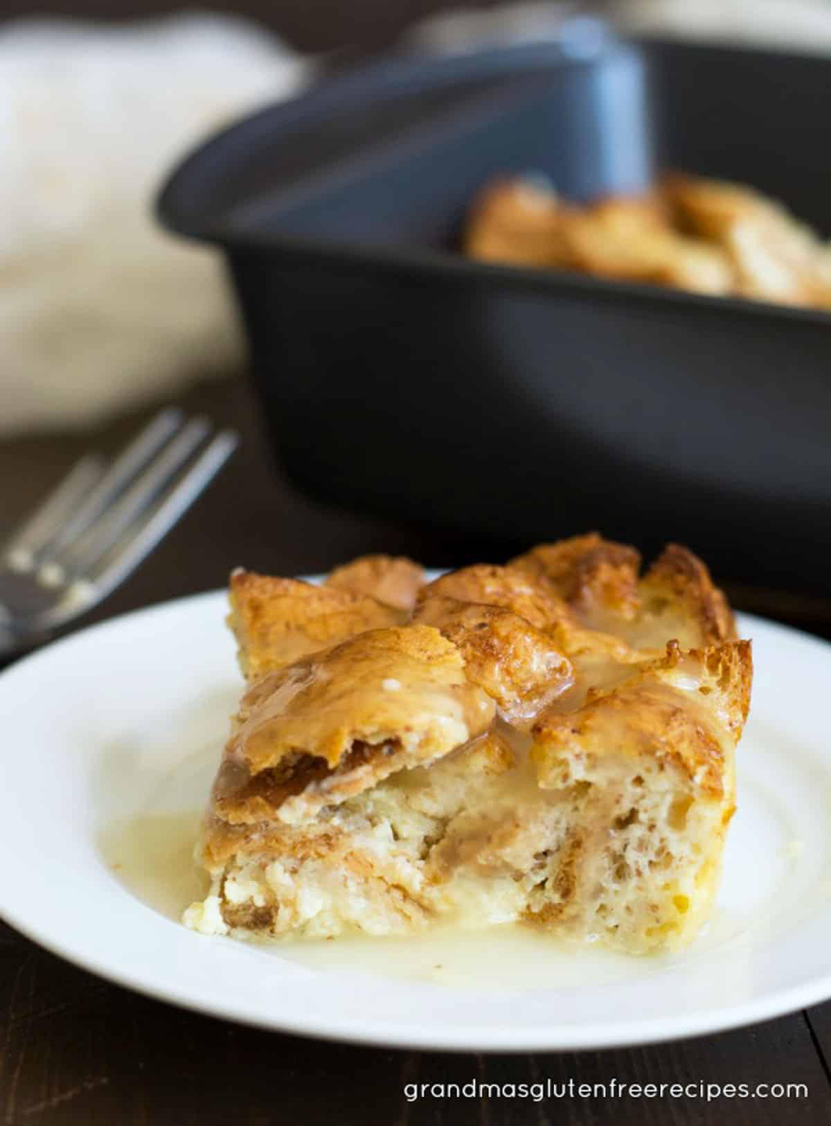 A slice of gluten free bread pudding on a white plate.