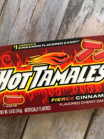 A box of hot tamales on a wooden table.