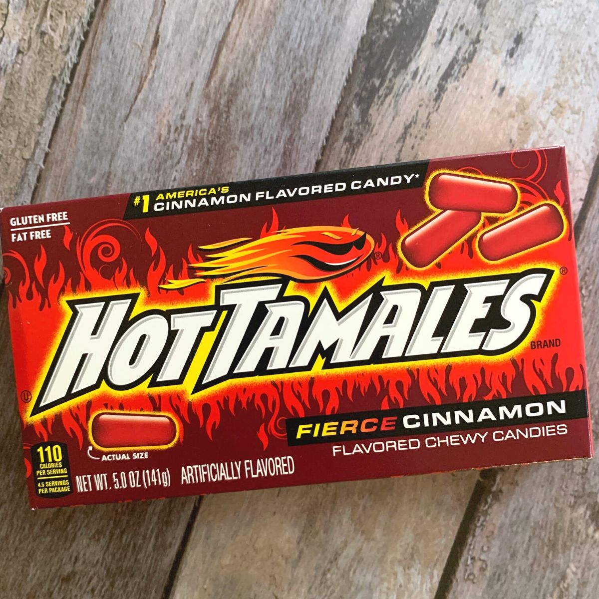 A box of hot tamales on a wooden table.