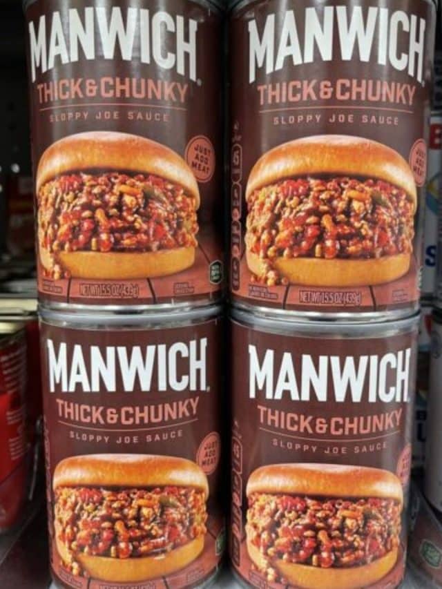 A photo of cans of Manwich on a grocery shelf.