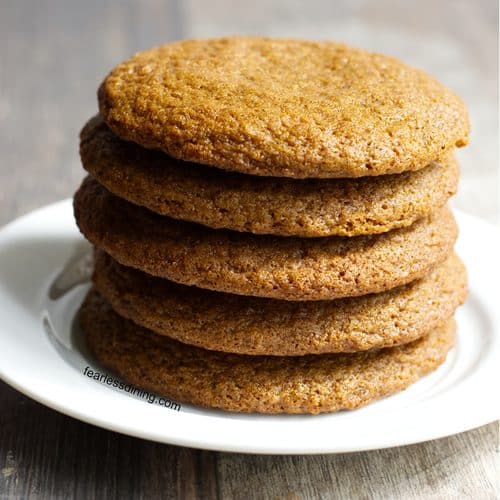A stack of five gluten free molasses cookies on a plate.
