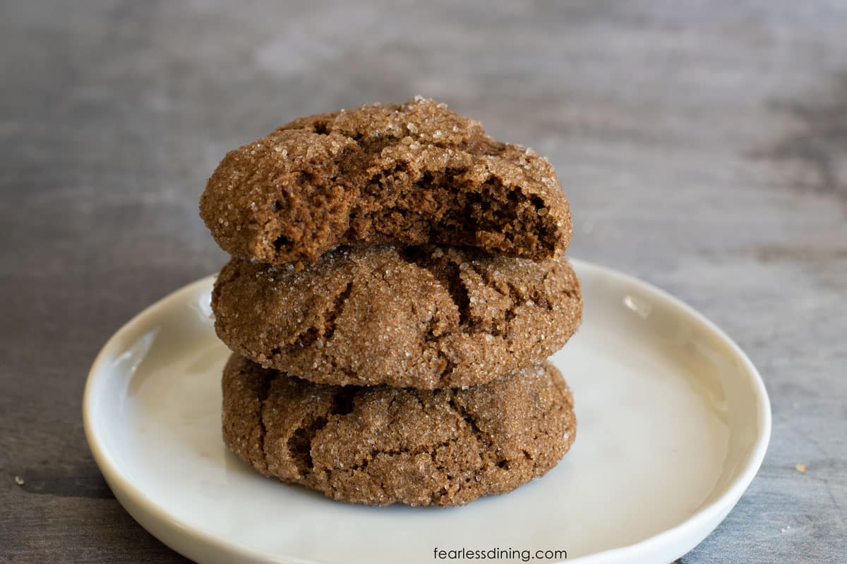 A stack of three pumpkin molasses cookies. The top cookie has a bite missing.