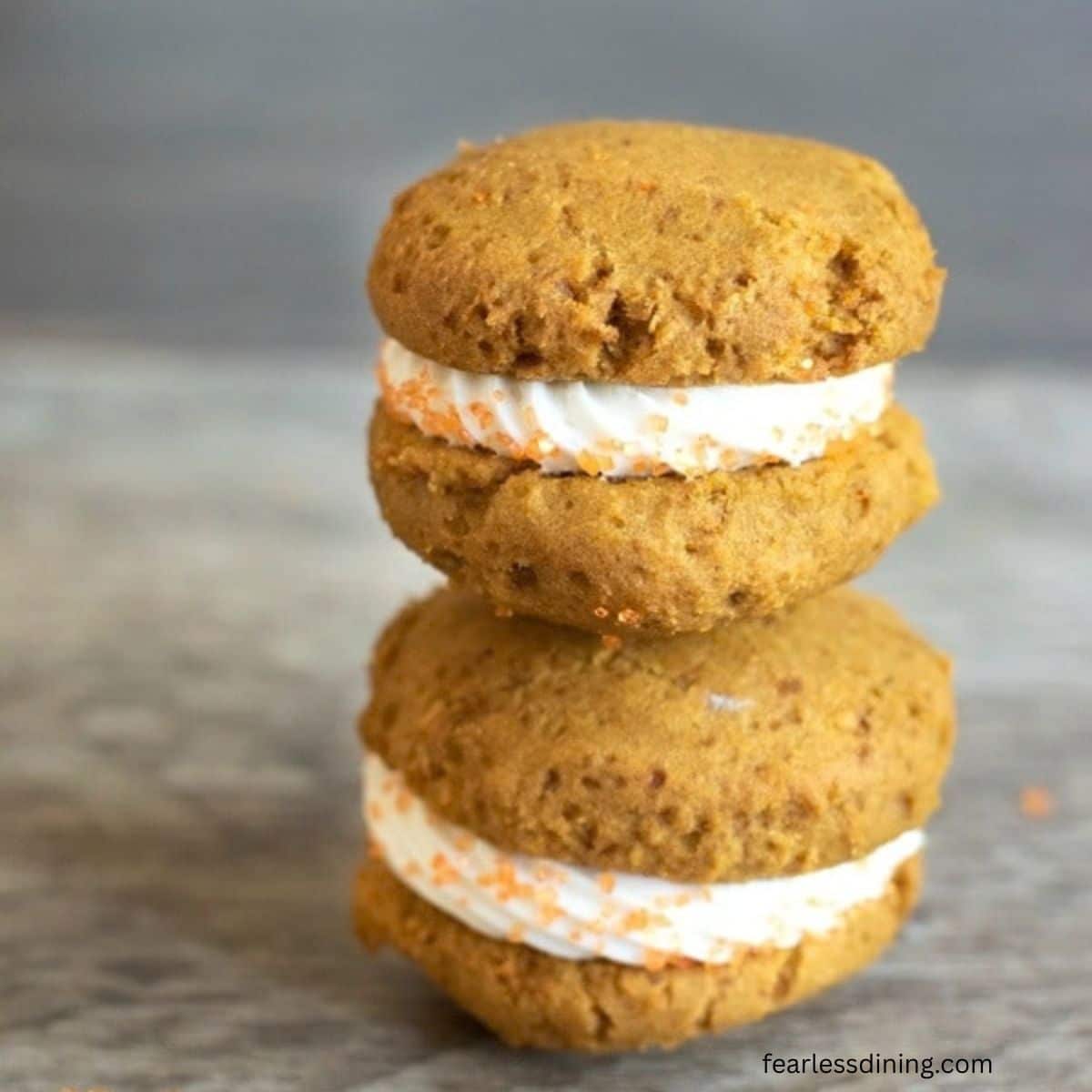Two gluten free pumpkin whoopie pies on the counter.
