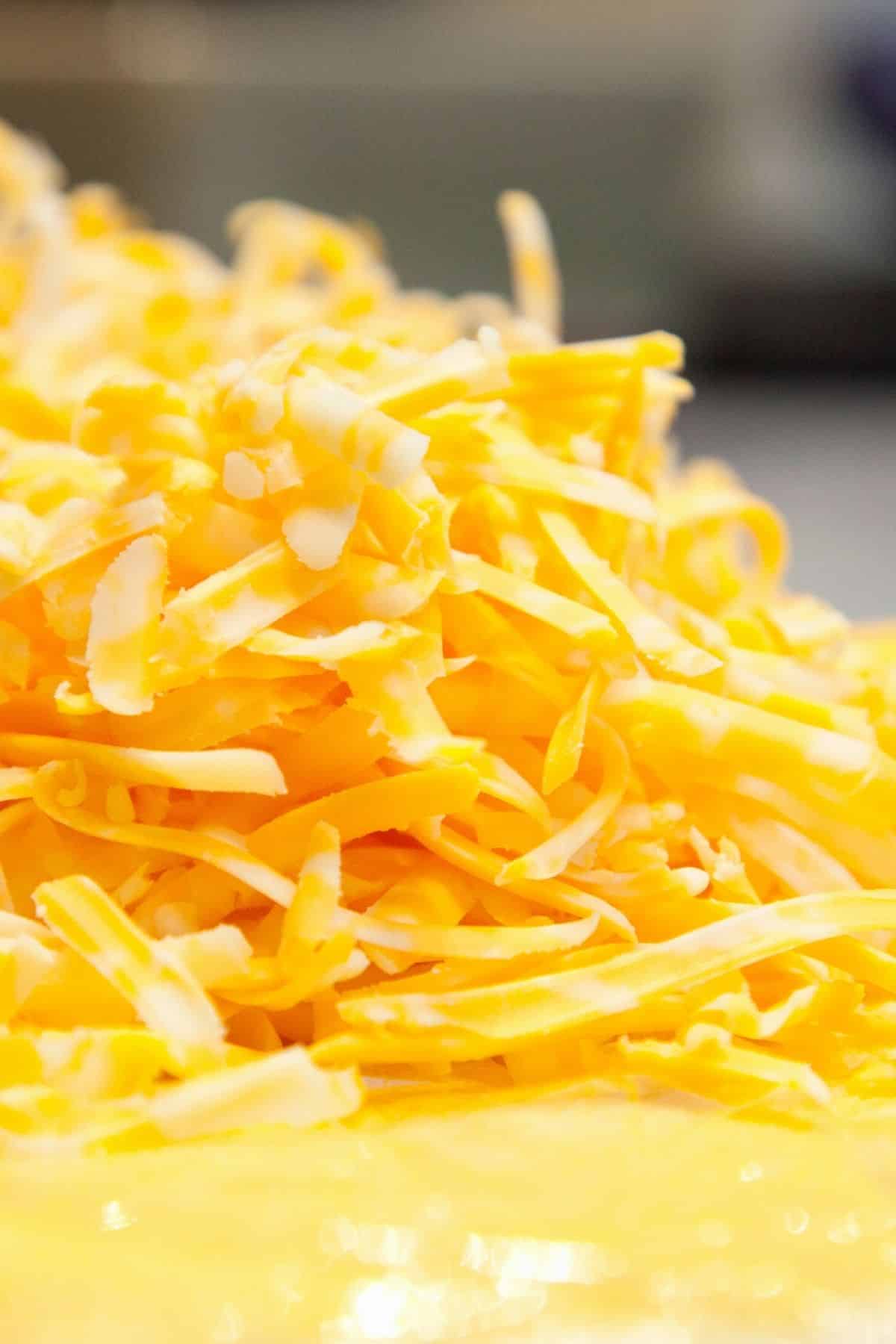 A pile of shredded cheddar cheese.