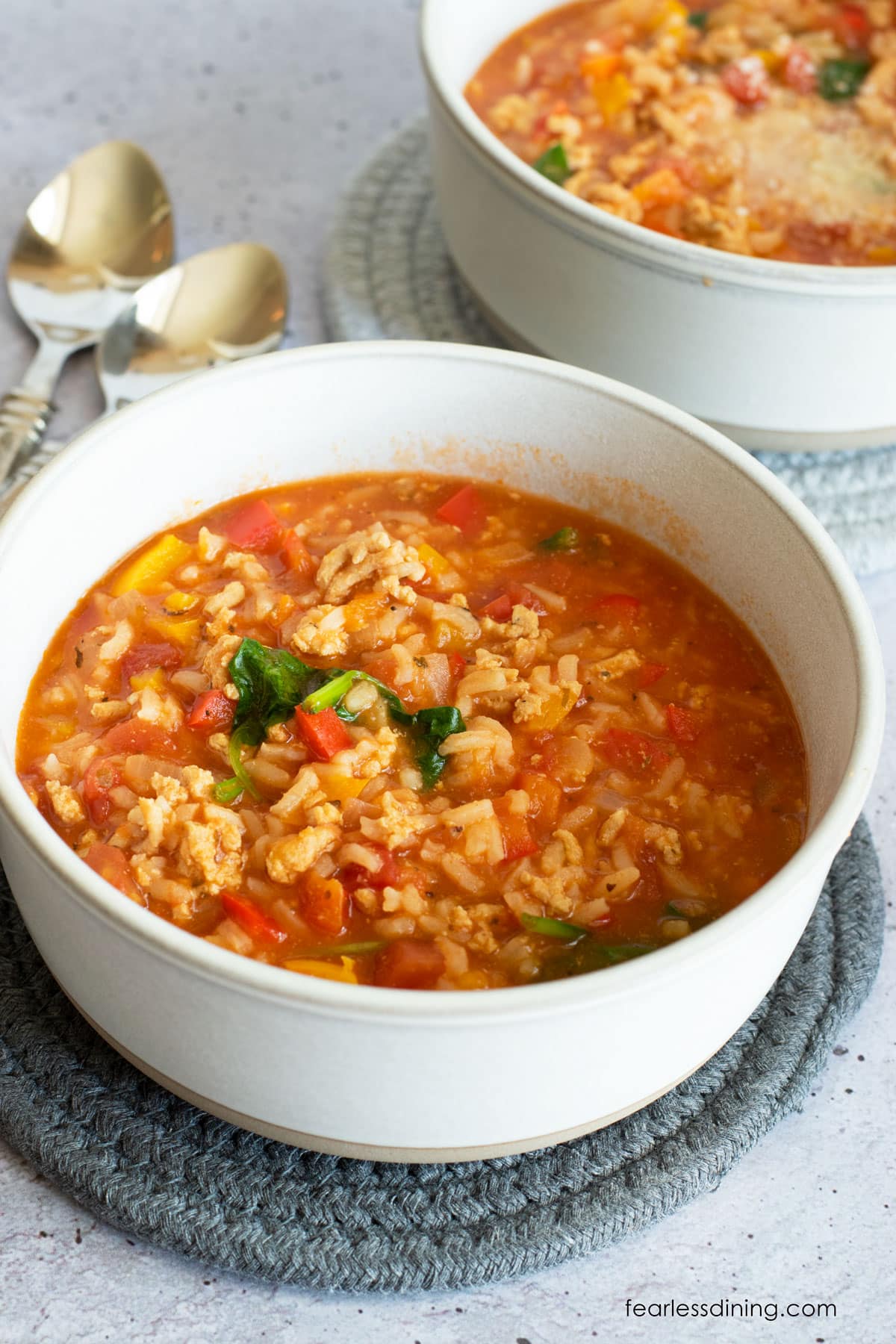 Two white bowls filled with the unstuffed pepper soup.