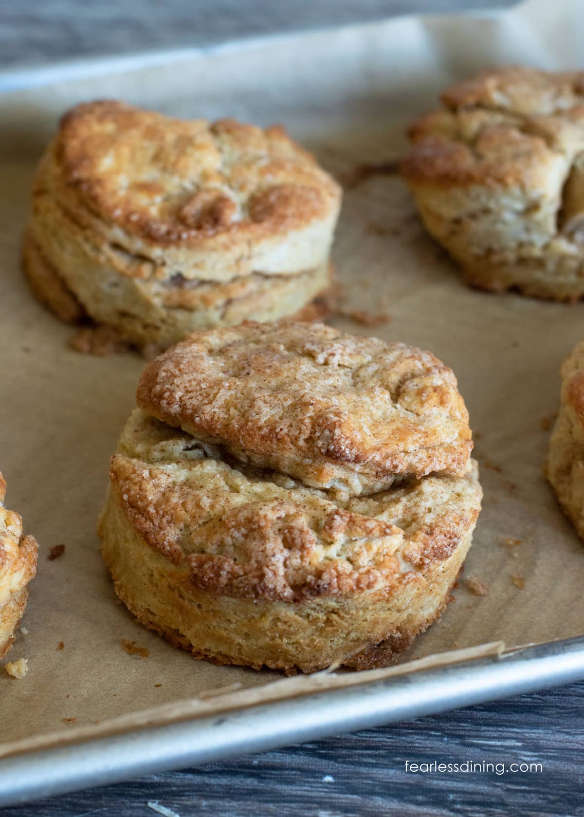 gluten free biscuits on a parchment paper lined sheet pan.