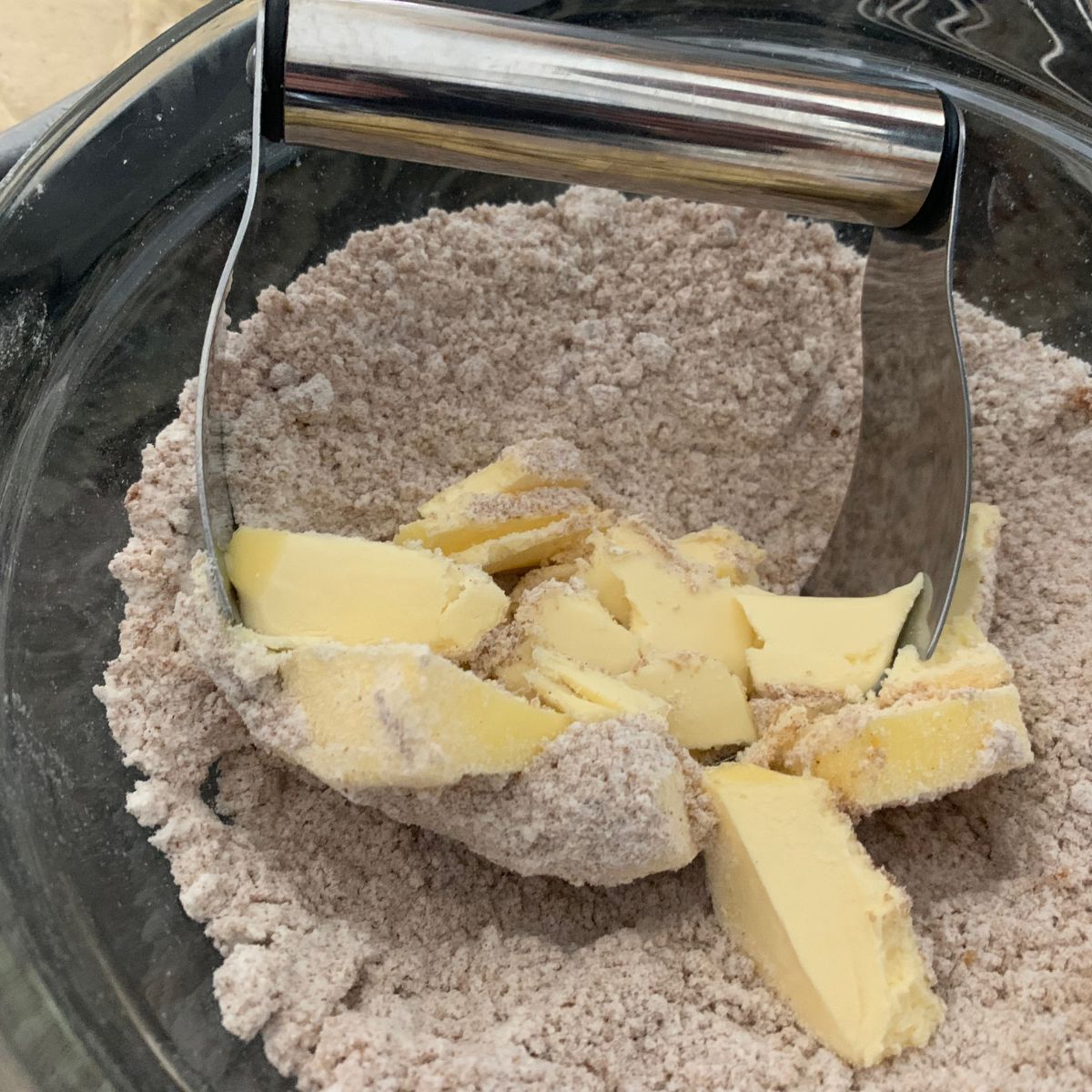 Cutting cold butter into the crumb topping.