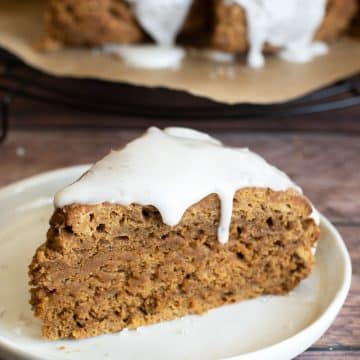 An iced gluten free gingerbread scone on a plate.