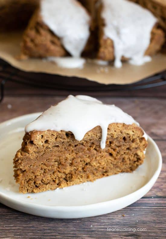 An iced gluten free gingerbread scone on a plate.