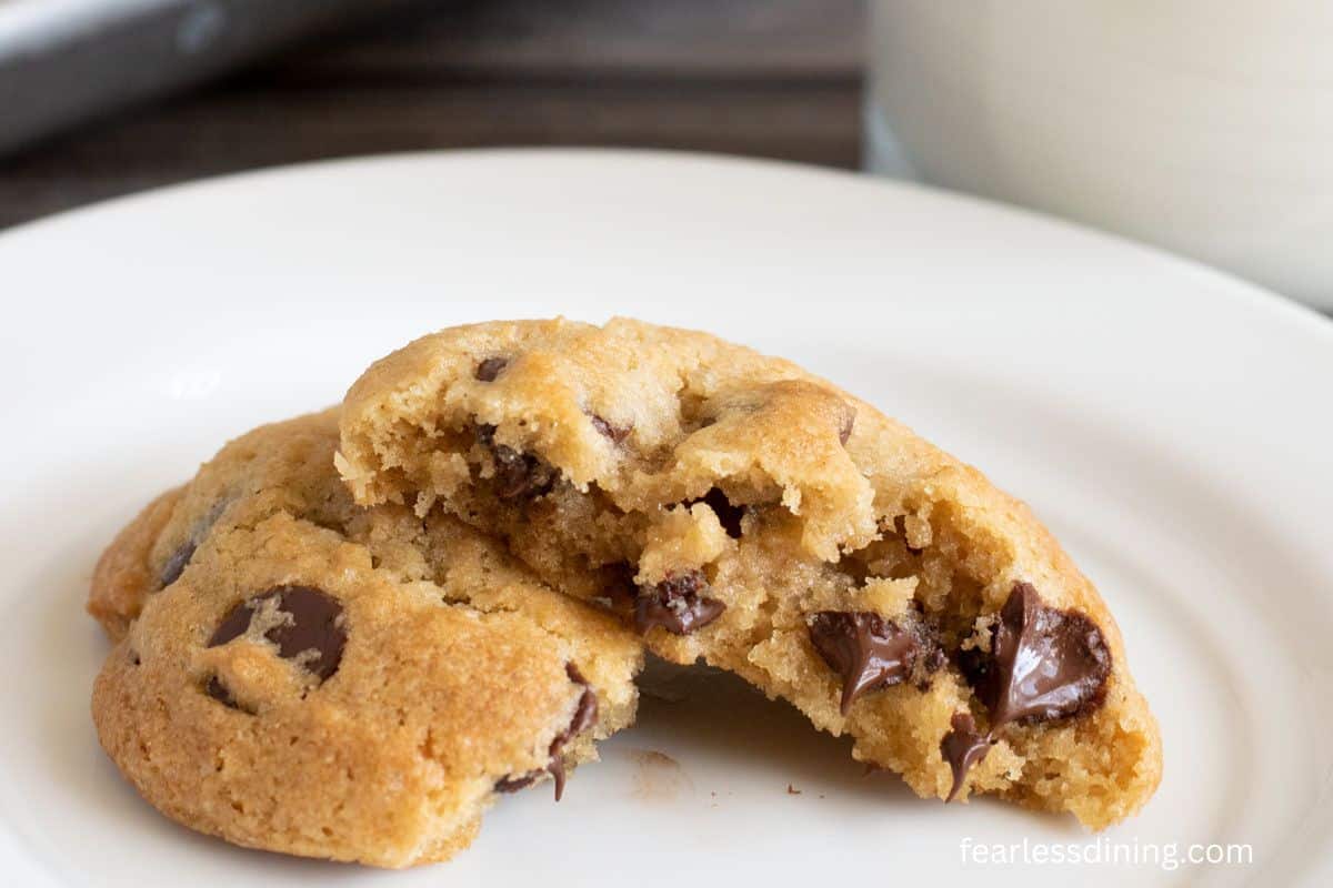 A toll house cookie broken in half on a plate.