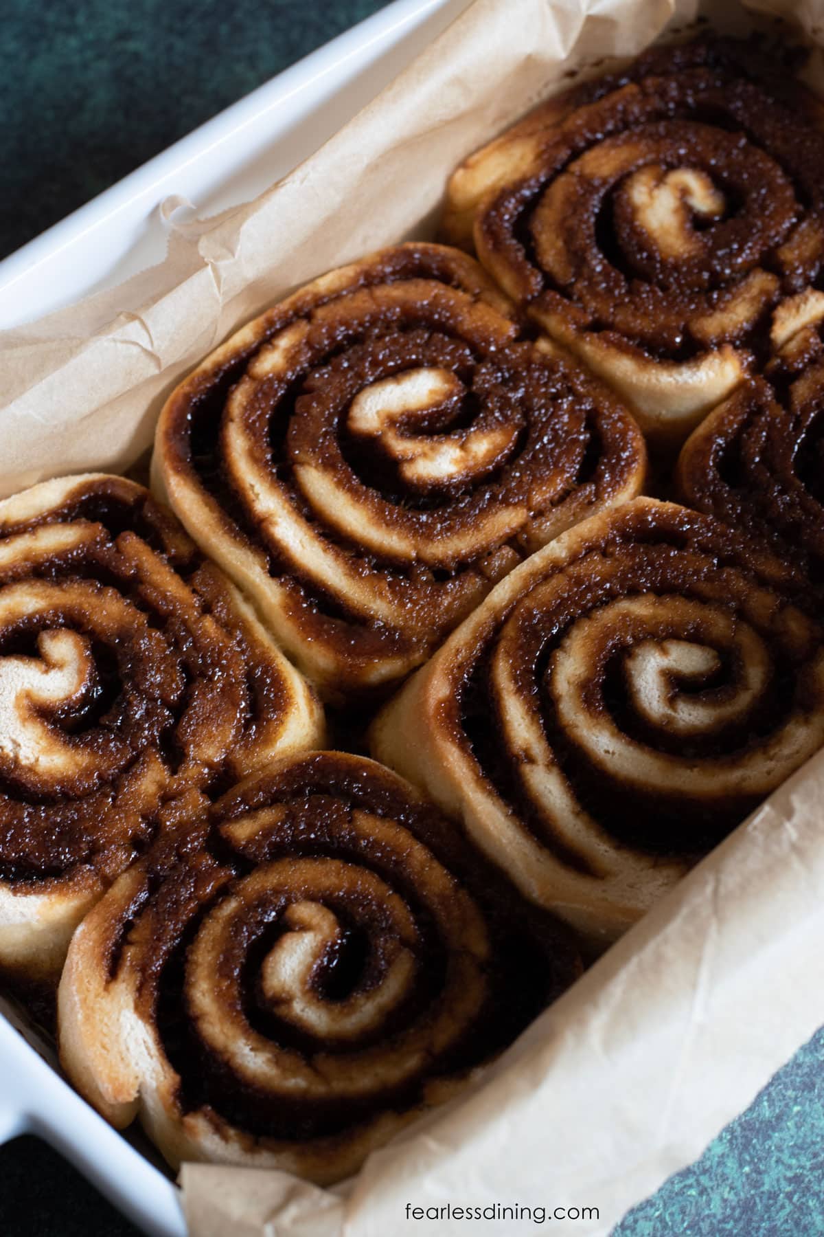The baked gluten free gingerbread cinnamon rolls in a baking dish.
