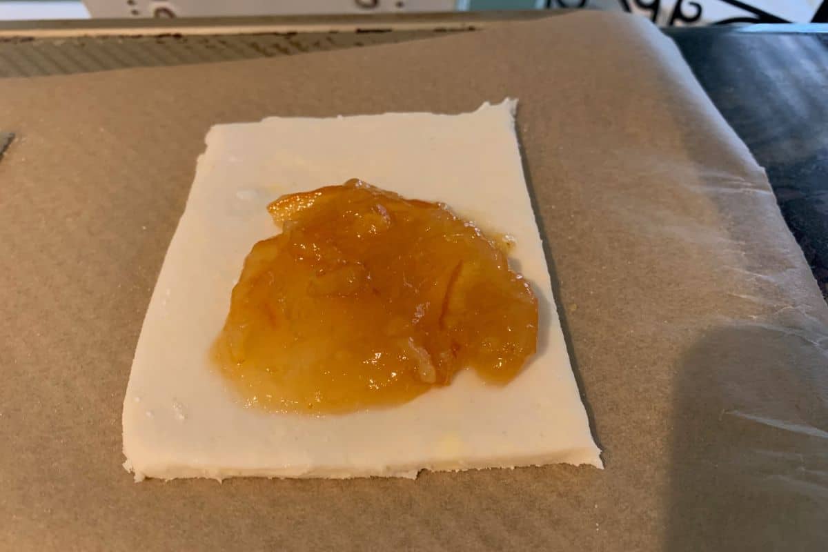 Orange marmalade on a pastry, ready to fold.