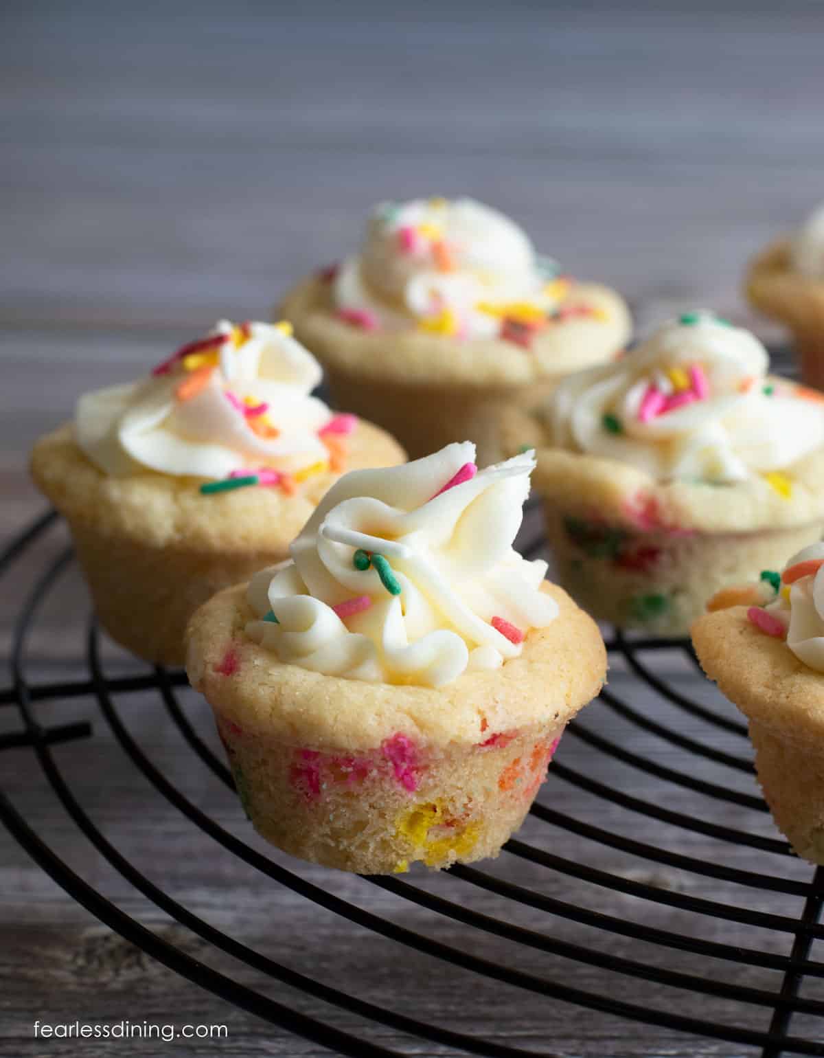 Gluten free funfetti cookie cups on a black wire rack.