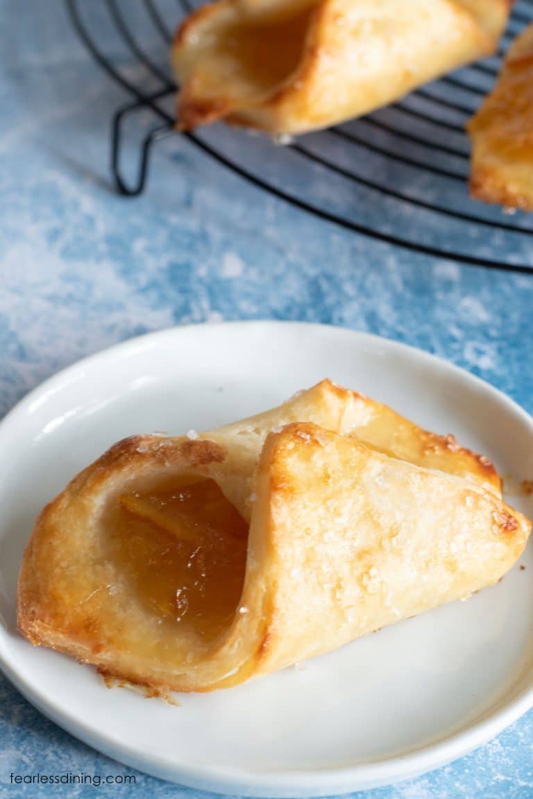 A pastry filled with orange marmalade on a white plate.