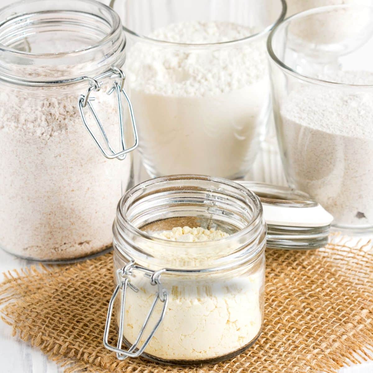 Four storage jars filled with gluten free flour blends.