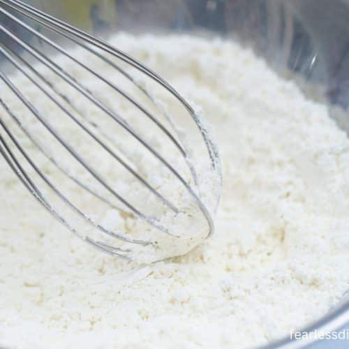 Whisking flour in a bowl.