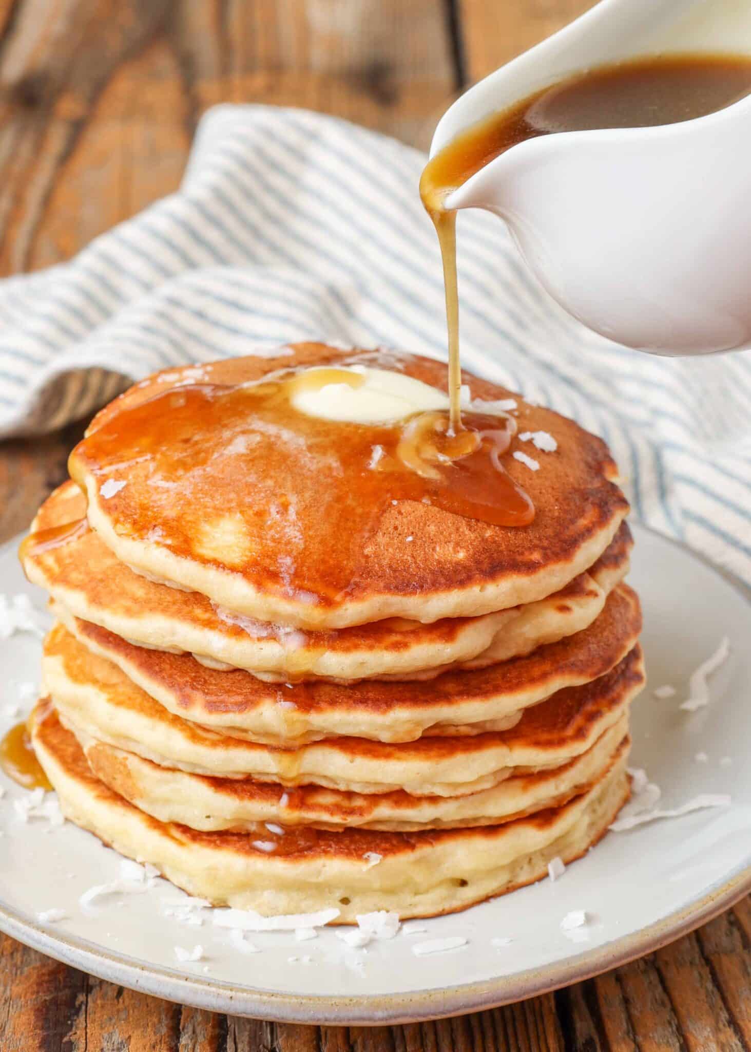 A stack of pancakes with brown sugar syrup.