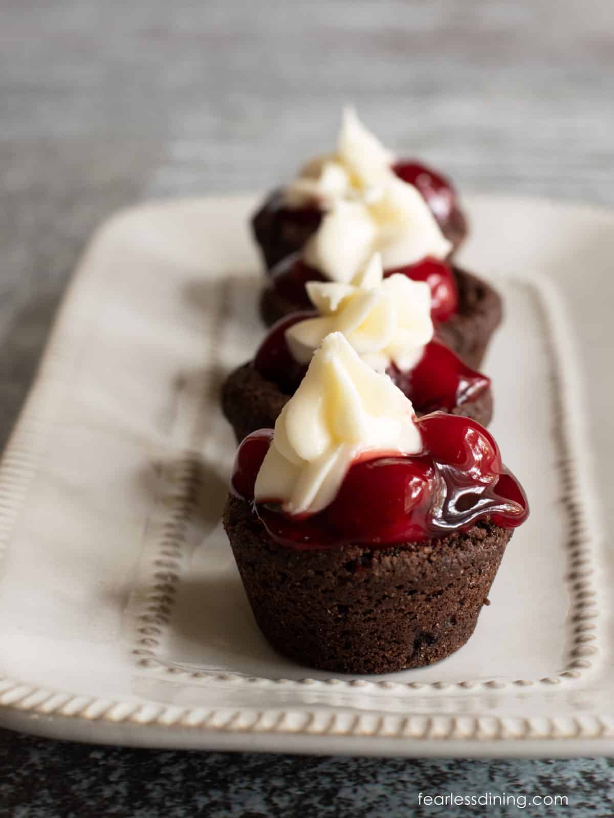 A row of black forest cookie cups on a white platter.