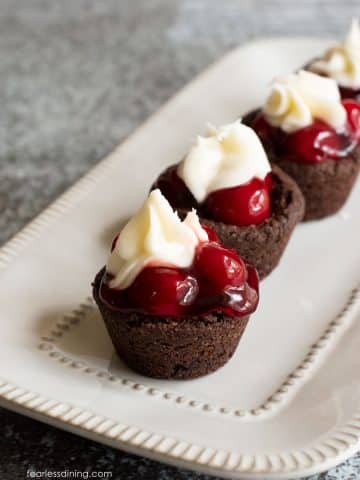 A row of black forest cookie cups on a rectangular platter.