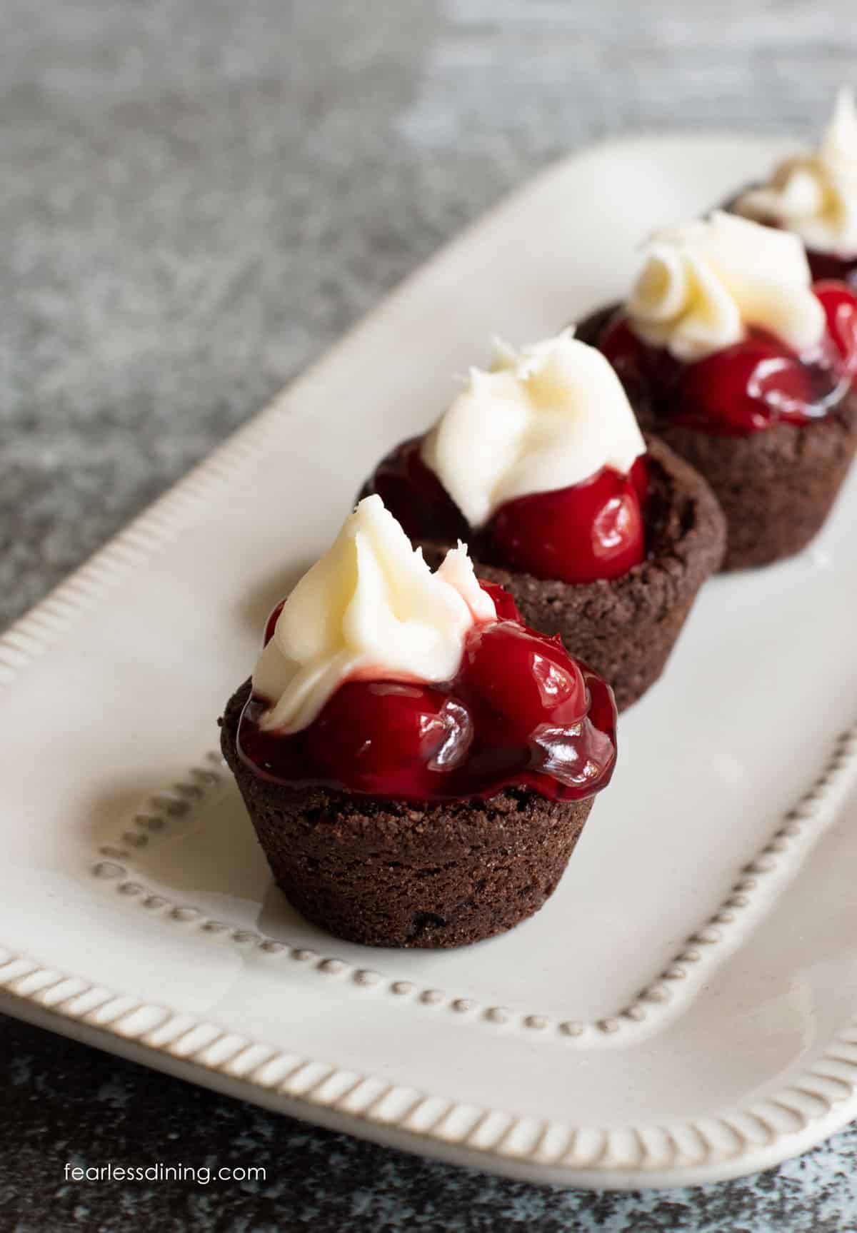 A row of black forest cookie cups on a rectangular platter.