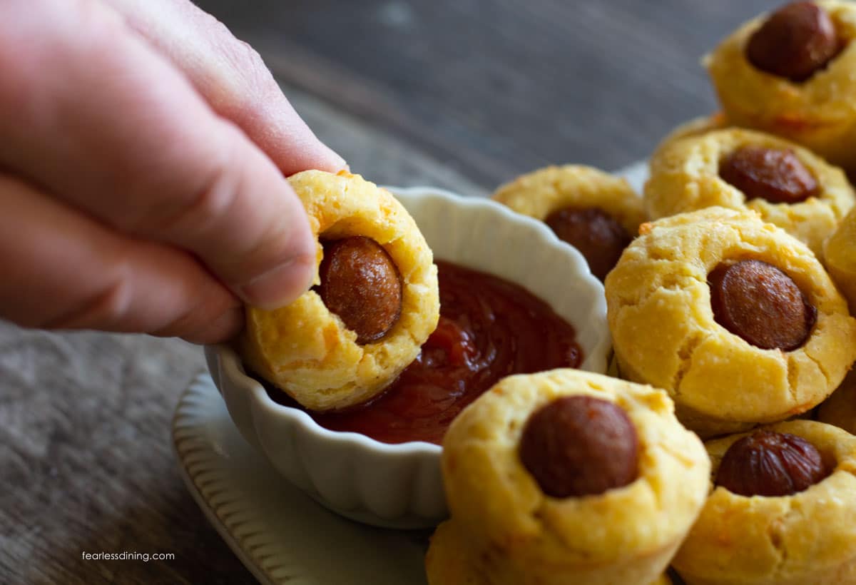 Dipping a corn dog muffin in ketchup.