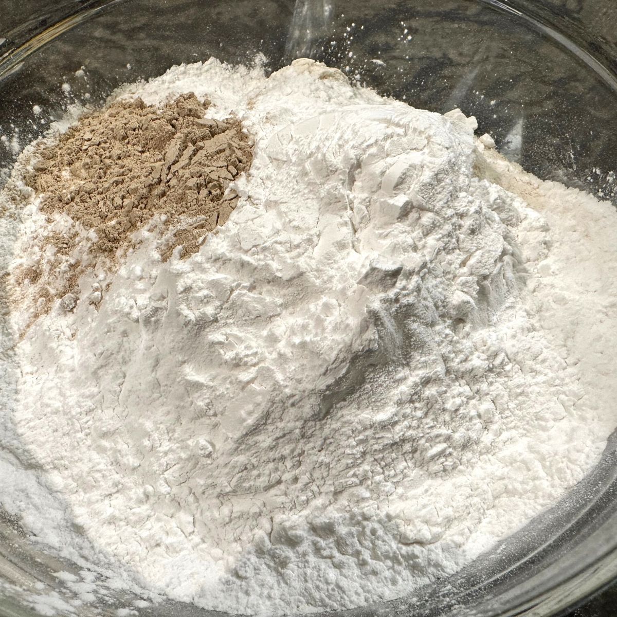 All of the types of gluten free flour and psyllium husk in a large mixing bowl.