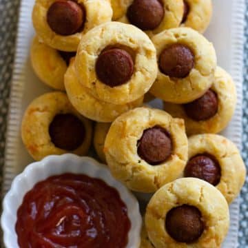 A rectangular platter filled with mini corn dog muffins.