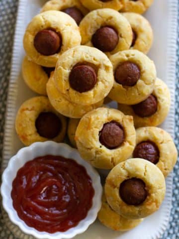 A rectangular platter filled with mini corn dog muffins.