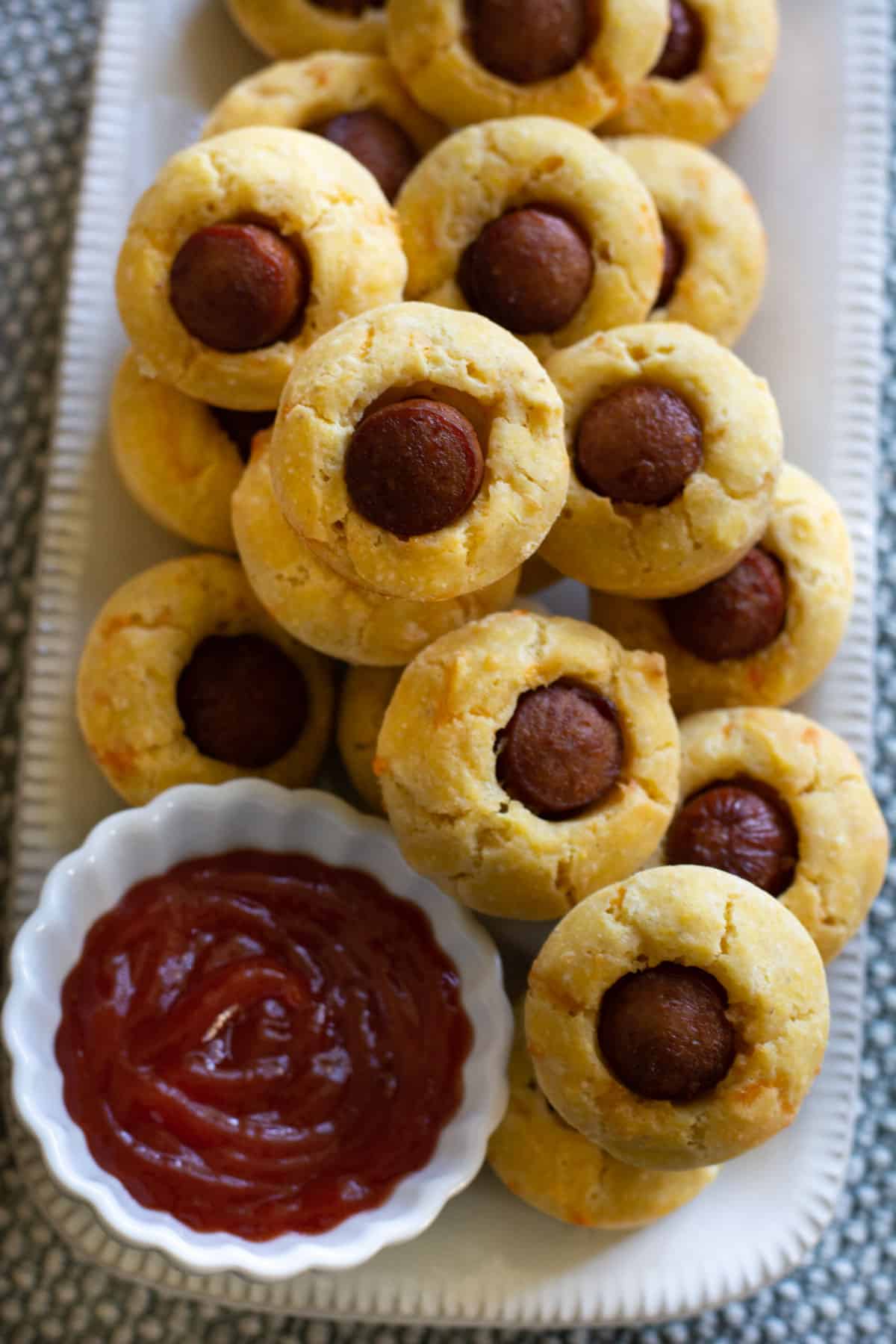 A rectangular platter filled with mini corn dog muffins.