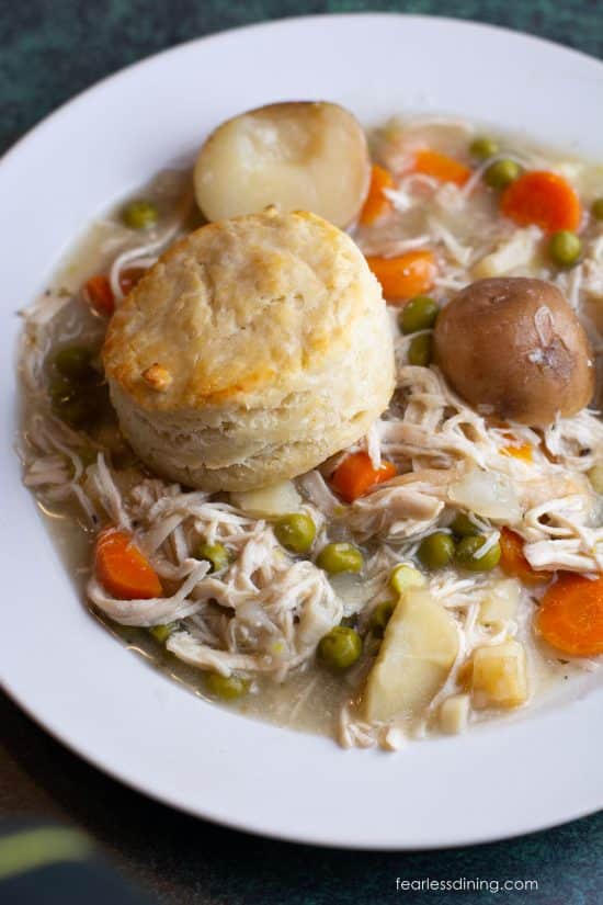 A plate of slow cooker chicken pot pie topped with a biscuit.