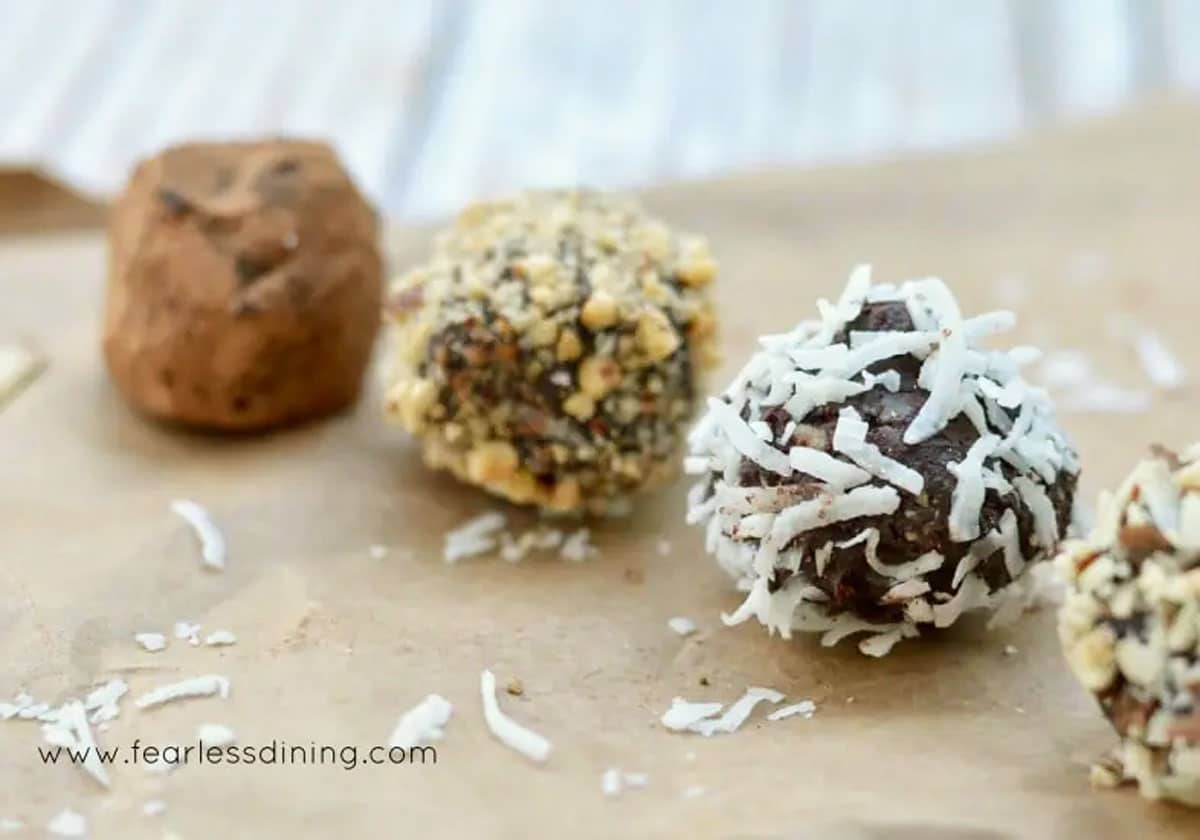 A row of four gluten free truffles, each with a different coating.